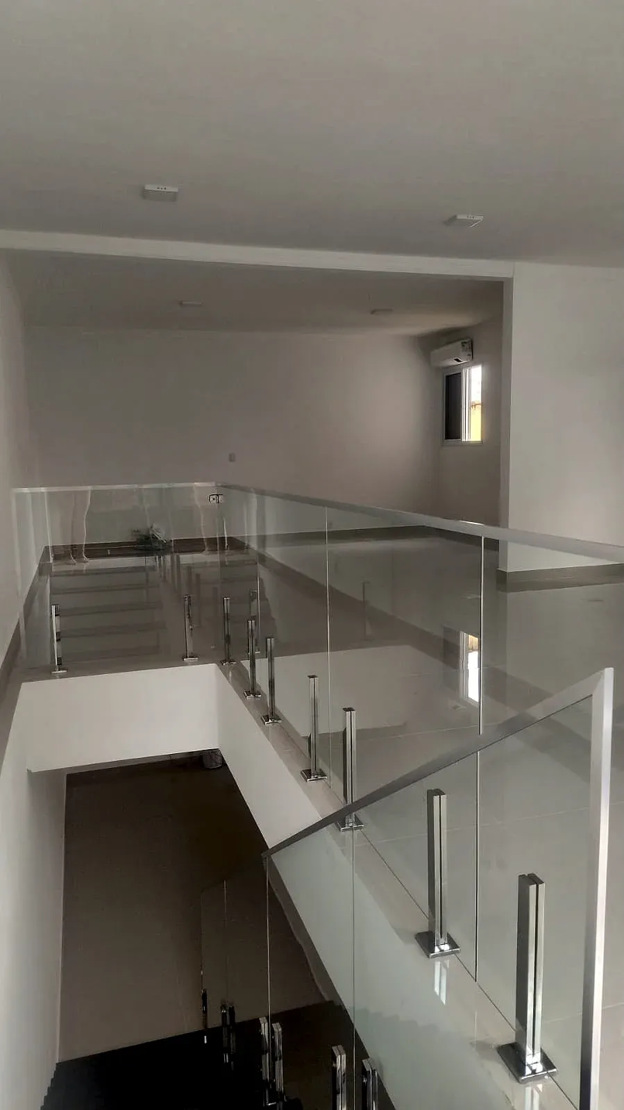 Guarda-corpo de vidro temperado com torres de inox no mezanino e na escada