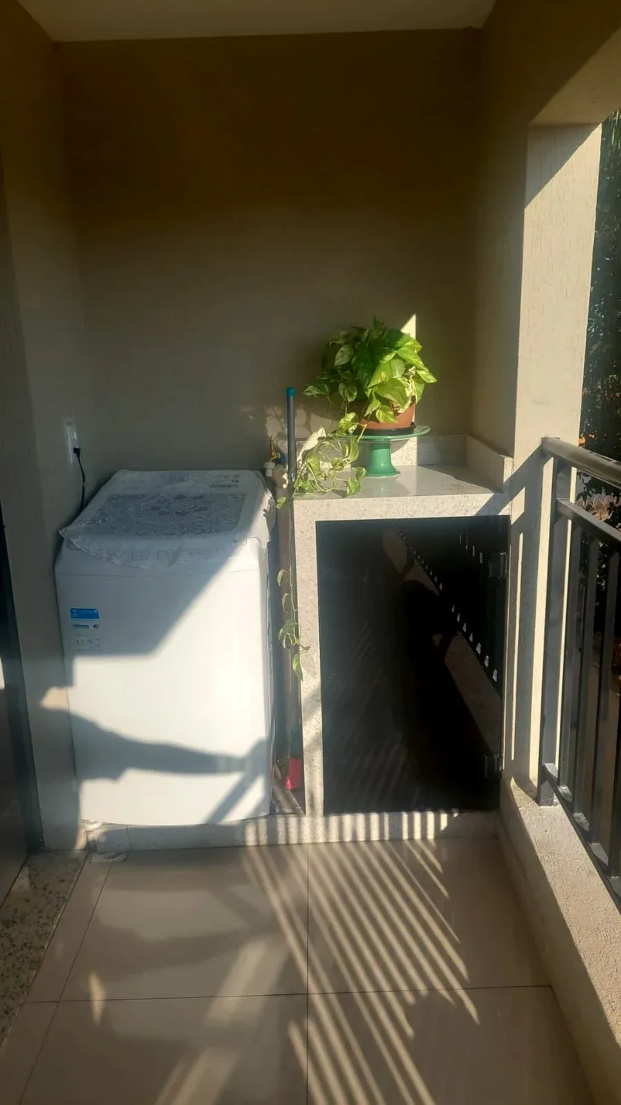 Porta de vidro com película escura embaixo do tanque na área de serviço