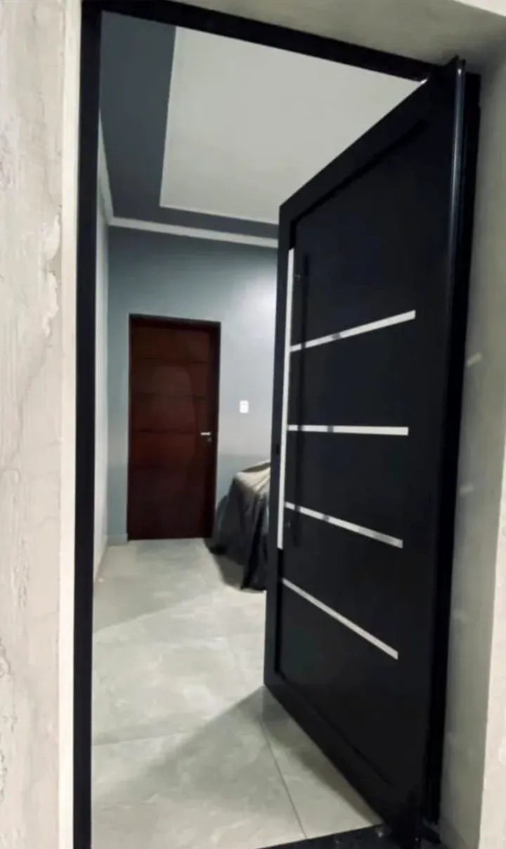 Porta pivotante em lambril de alumínio preto com frisos e puxador