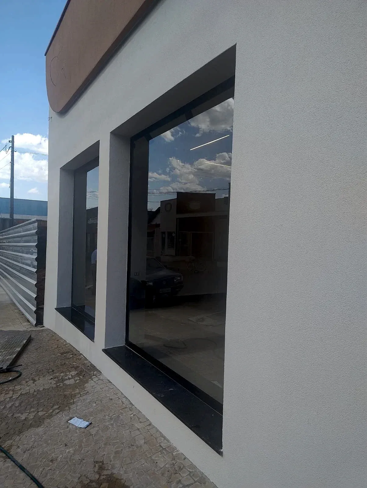 Fachada comercial com vidros fixos em esquadria de alumínio preto