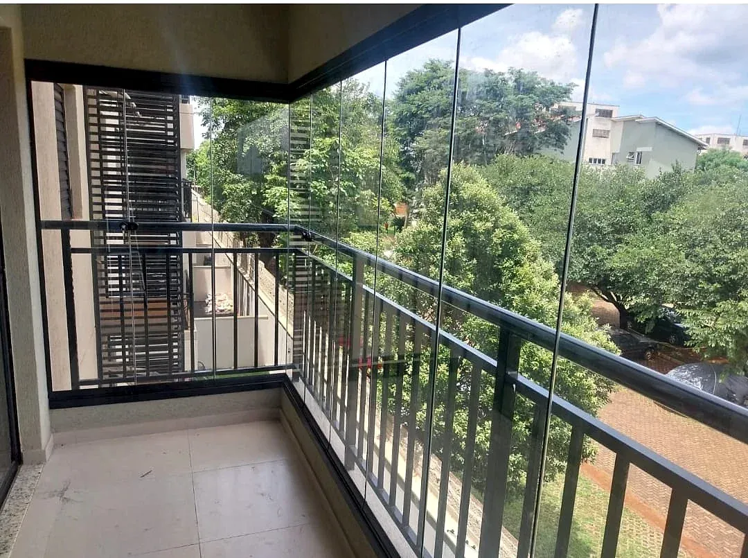Sacada envidraçada com guarda-corpo, vista para as árvores